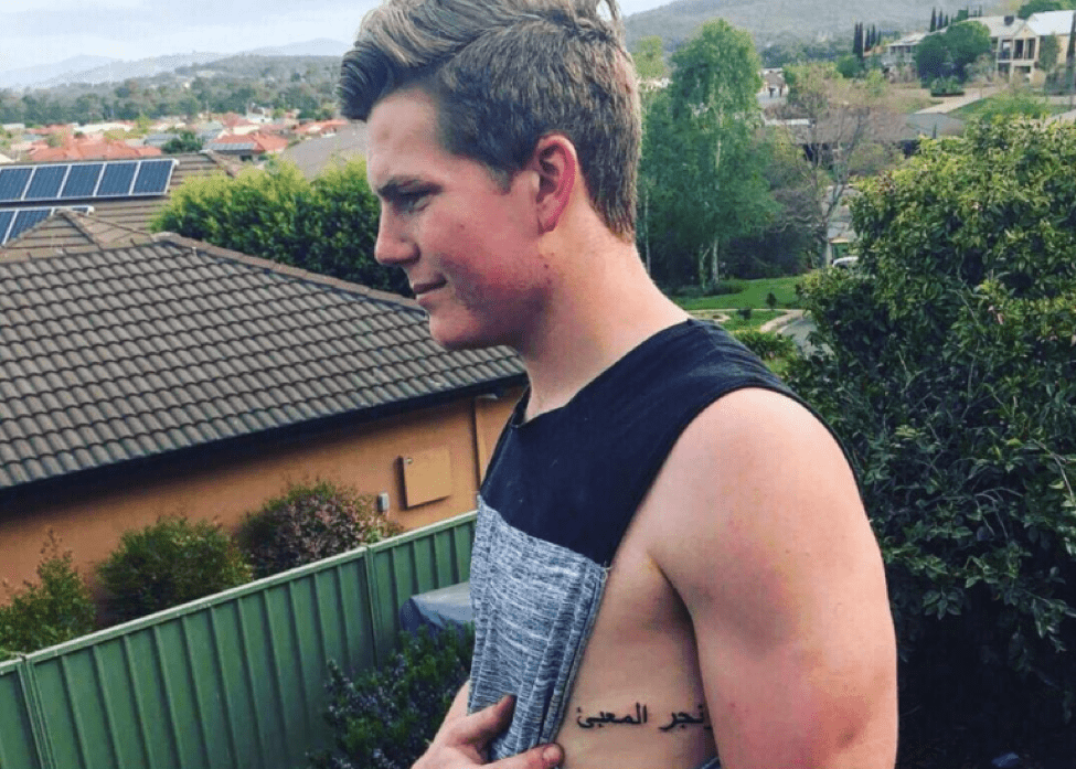 A boy showing tattoo on under arm