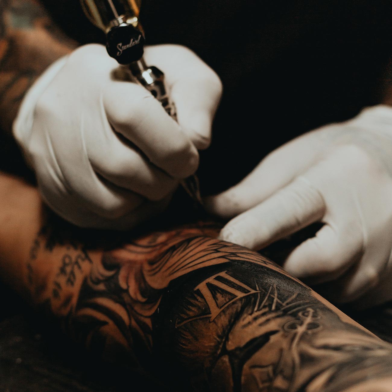 tattoo artist create tattoo on arm