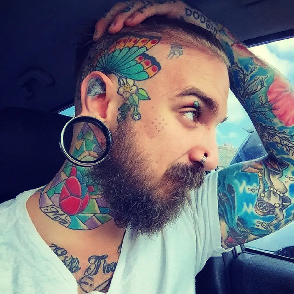 DANIEL HOWLAND showing his piercing and tattoo